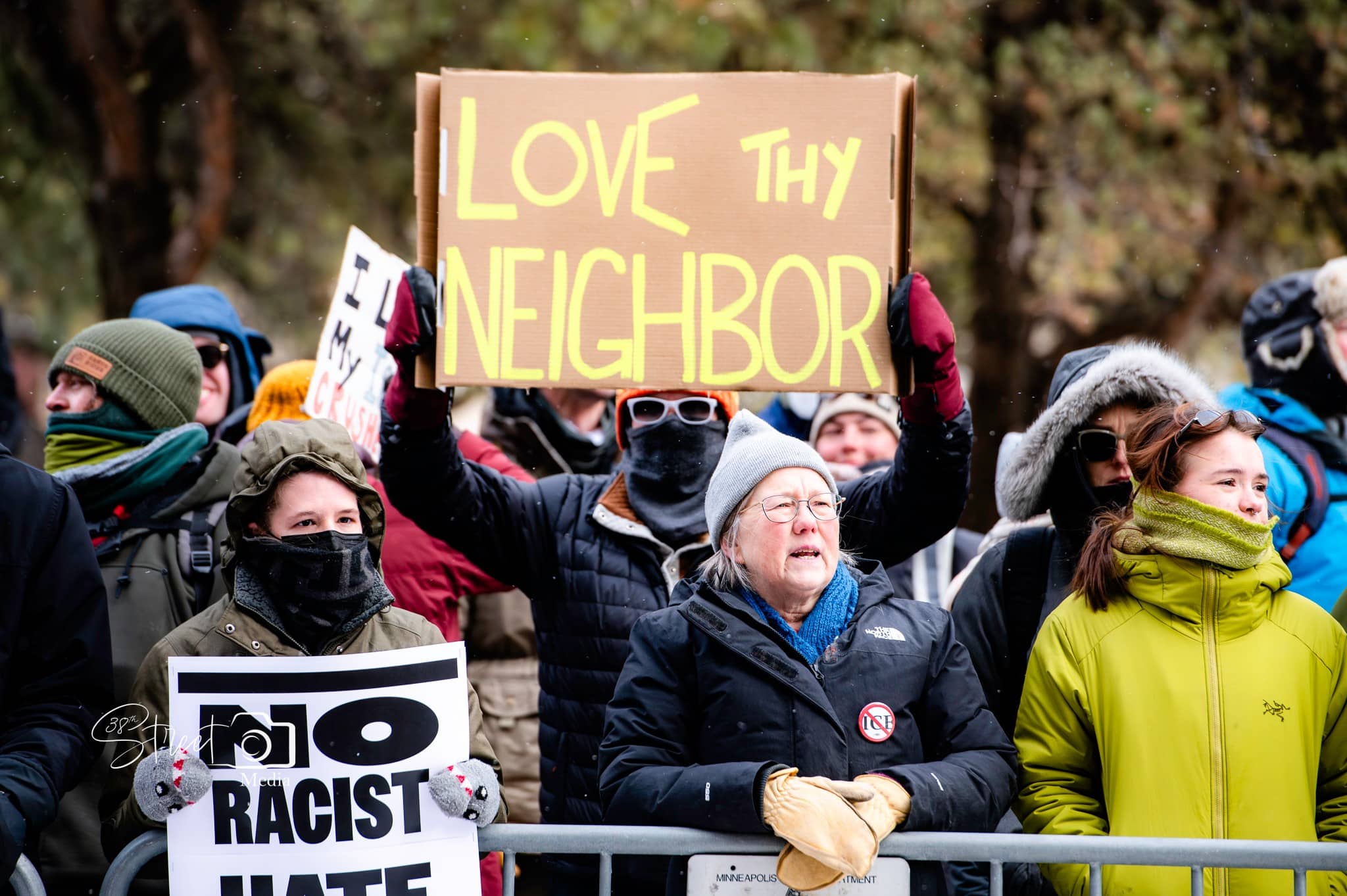 love thy neighbor sign held high
